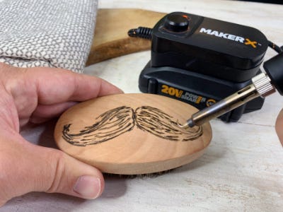 wood and metal engraving mustache onto brush front view