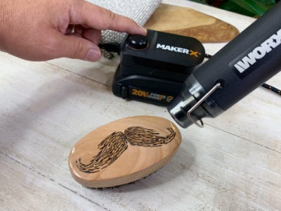 using heat gun to apply prection cover on wood brush