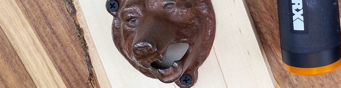 close up of bear face on wooden wall mount bottle opener