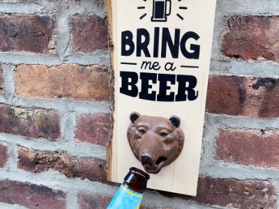 bottle opened by bear bottle opener hanging on brick wall