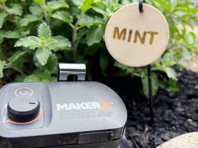 battery and charger of wood engraved tool next to mint hanging from tree