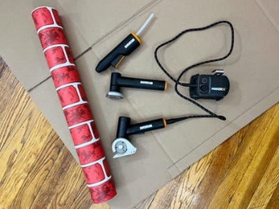 worx angle grinder, zipsnip, and hot glue gun next to red brick wrapping paper