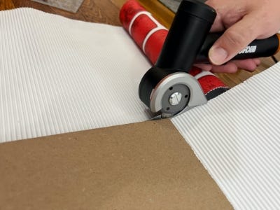 using rotary tool to cut around cardboard box