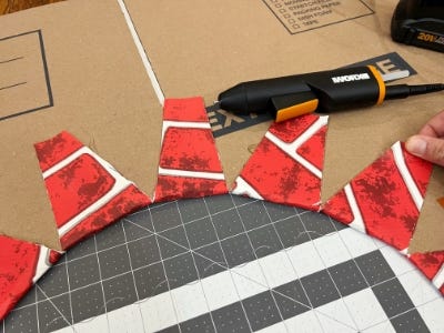 mini glue gun on top of cardboard and red and white paper