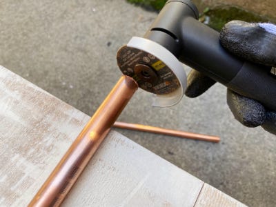 using the worx angle grinder to cut copper pipe off the side of the table