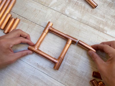 person connection copper pipes in a square shape