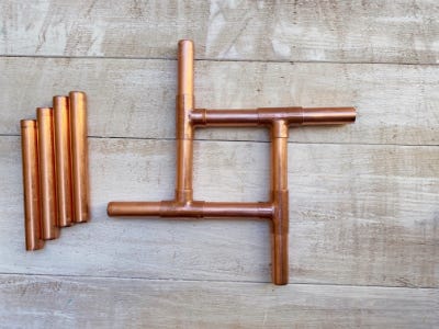 copper pipes in a square shape on table