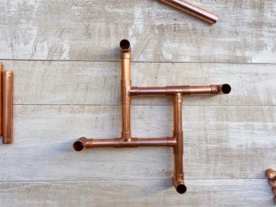 copper pipes in a square shape on table right upside