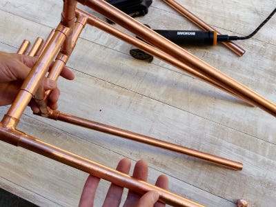 holding in air from table multiple copper pipes