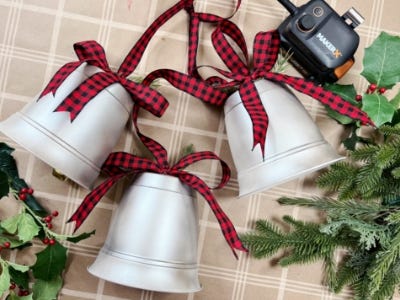 three silver red and black plaid ribbons laying side down next to battery and charger