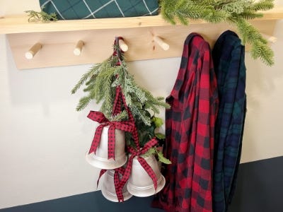 up top view of three silver red and black plaid ribbons hanging next to jacket hanger and 2 jackets