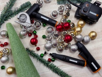 zipsnip, rotary drill, and heat gun laying down next to ornaments and green foam tree