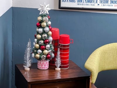 Oranament tree on table next to smaller silver trees and red cups