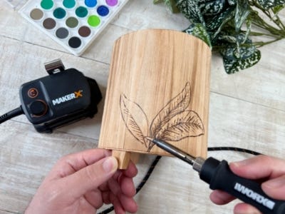 image of person using the wood and metal crafter tool to to trace the hand drawn design