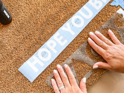 Pressing down tacos stencil onto doormat