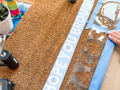 Using painters tape tape around tacos stencil onto doormat