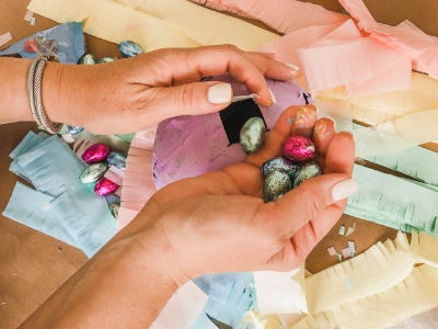 Hands holding 4 different color wrapped candies