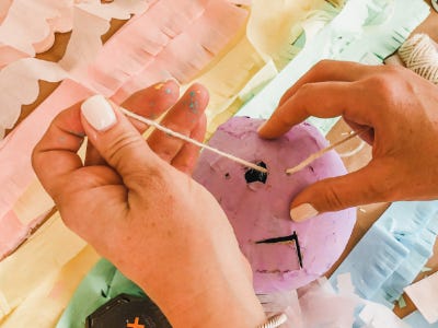 Threading yarn into holes into top of hard cased ballon shell