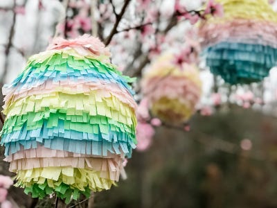 Colorful easters egg pinata hanging from pink flower tree