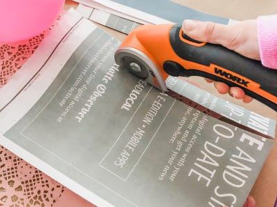 Newspaper being cut by orange zipsnip cutting tool