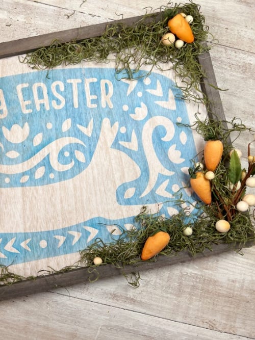 wooden Easter sign with moss and fake carrots in the corner