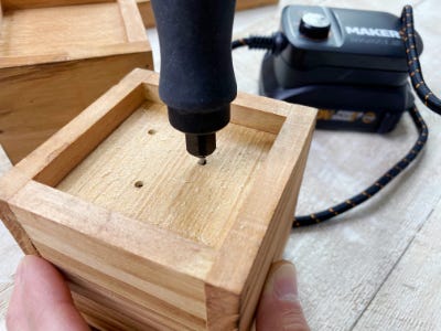 using rotary tool to drill hole into wood box