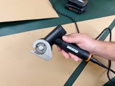 holding rotary cutter above cut cardboard