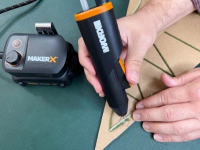 using mini glue gun to glue top piece to cardboard