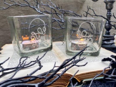 sketched skull glasses on top of open book and sticks