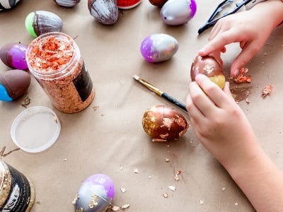 adding gold leaf flakes to yellow/brown egg