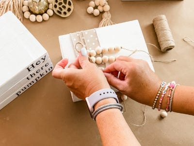 attaching threaded beads onto yarn thread and top of wood blocks