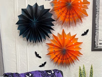 Orange and black pinwheels hanging on wall