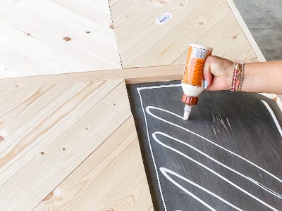 applying wood glue to top surface of table