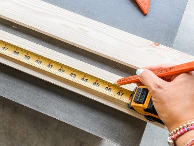 using measureing tape to mark spots on wood piece