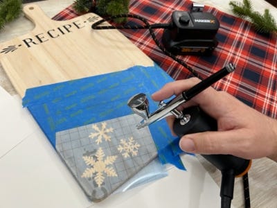 using airbrush to air brush paint onto snowflake