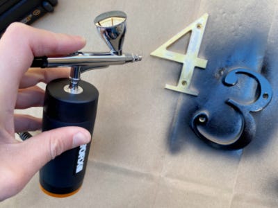 using air brush to paint the letter 3 black