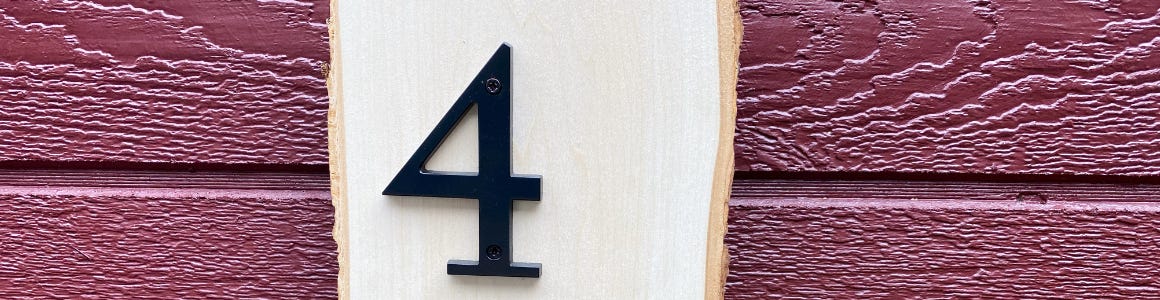 house number sign hanging from red brick