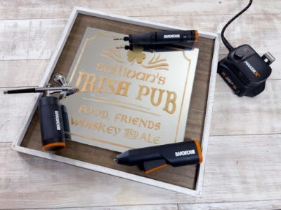 air brush, rotary tool, and hot glue gun on top of vintage irish pub sign