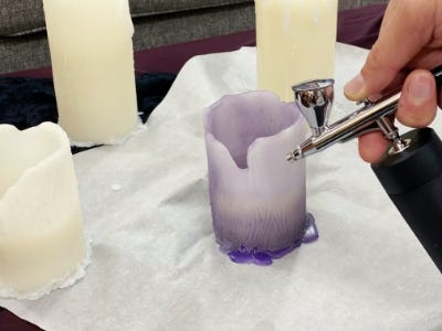 using air brush to paint purple color coat to candle