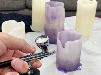 using air brush to paint purple color coat to candle smaller one