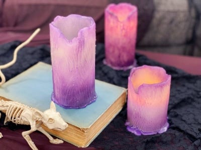 lighted purple color candle 3 different sizes and one on box