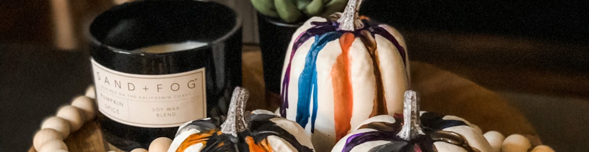 melted crayon pumpkin next to sand fog candle