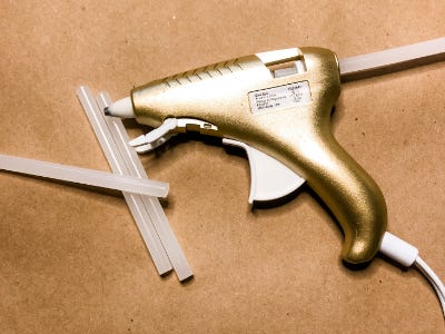 heat glue gun with glue sticks and brown paper