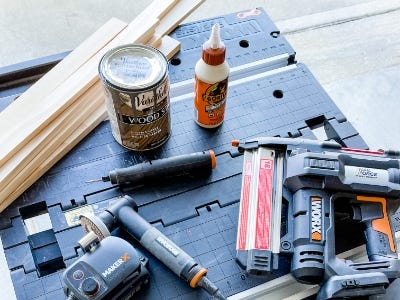 work table with Worx Miter saw, glue, wood, and other supplies on it