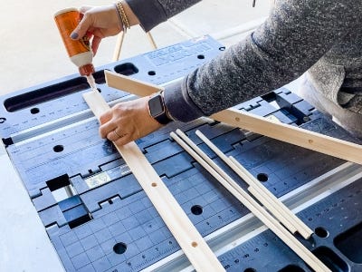 image of a person gluing the wooden dowels into the hole of the wooden triangle