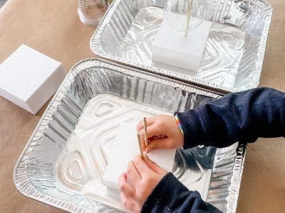 styrofoam blocks inside aluminum tray with wooden skewers inserted