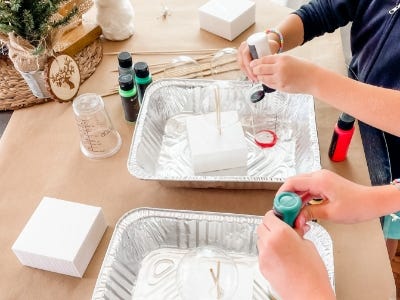 squeezing paints into cups inside aluminum tray