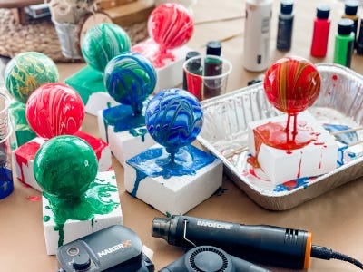 9 different colored ornaments drying on styrofoam