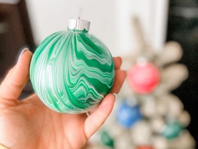 hand holding green swirled color ornament