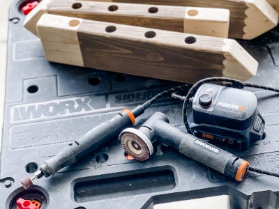 two pencil looking wood pieces next to rotary and angle grinder